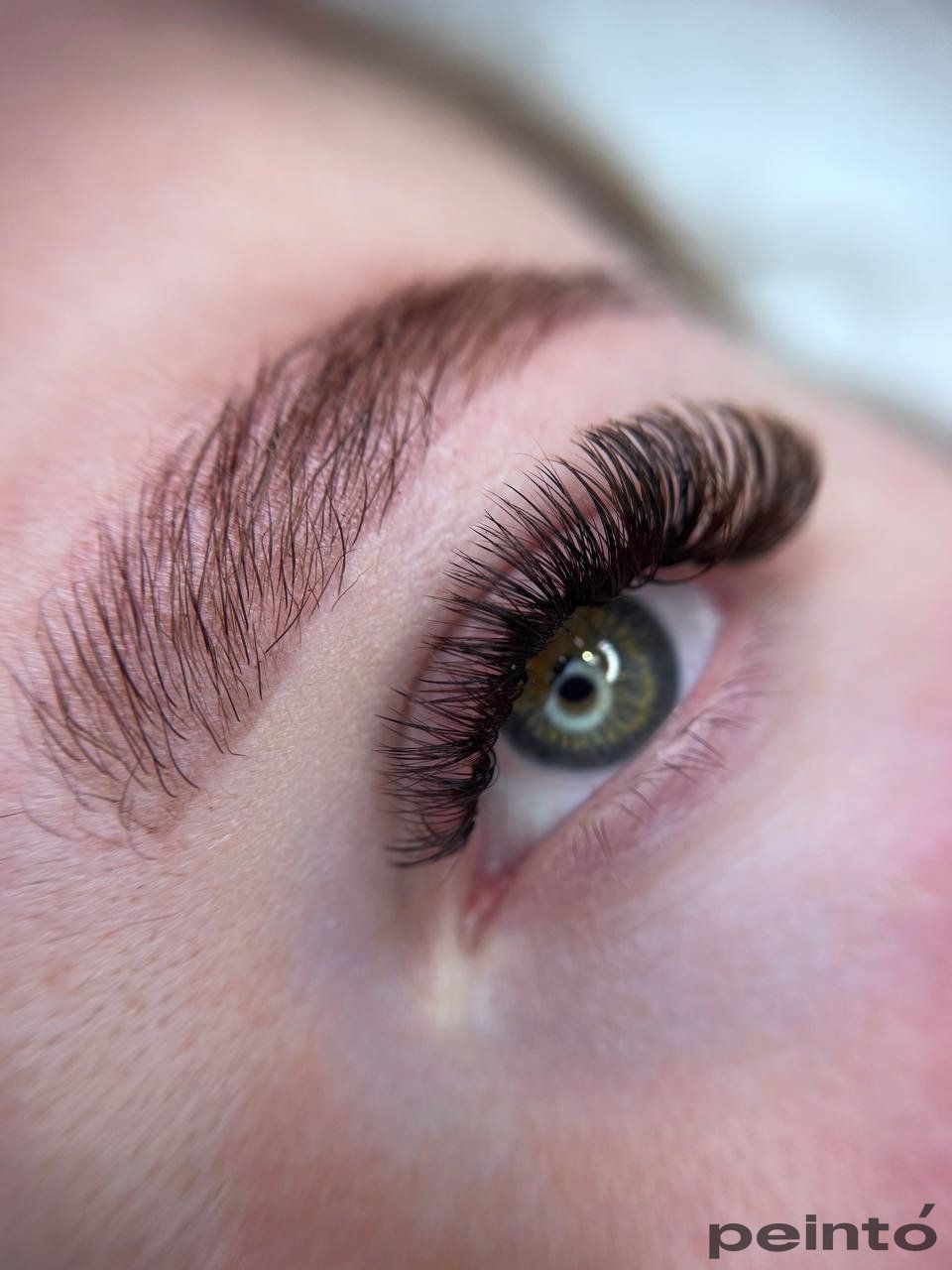 Eine Nahaufnahme des Auges einer Frau mit langen Wimpern.