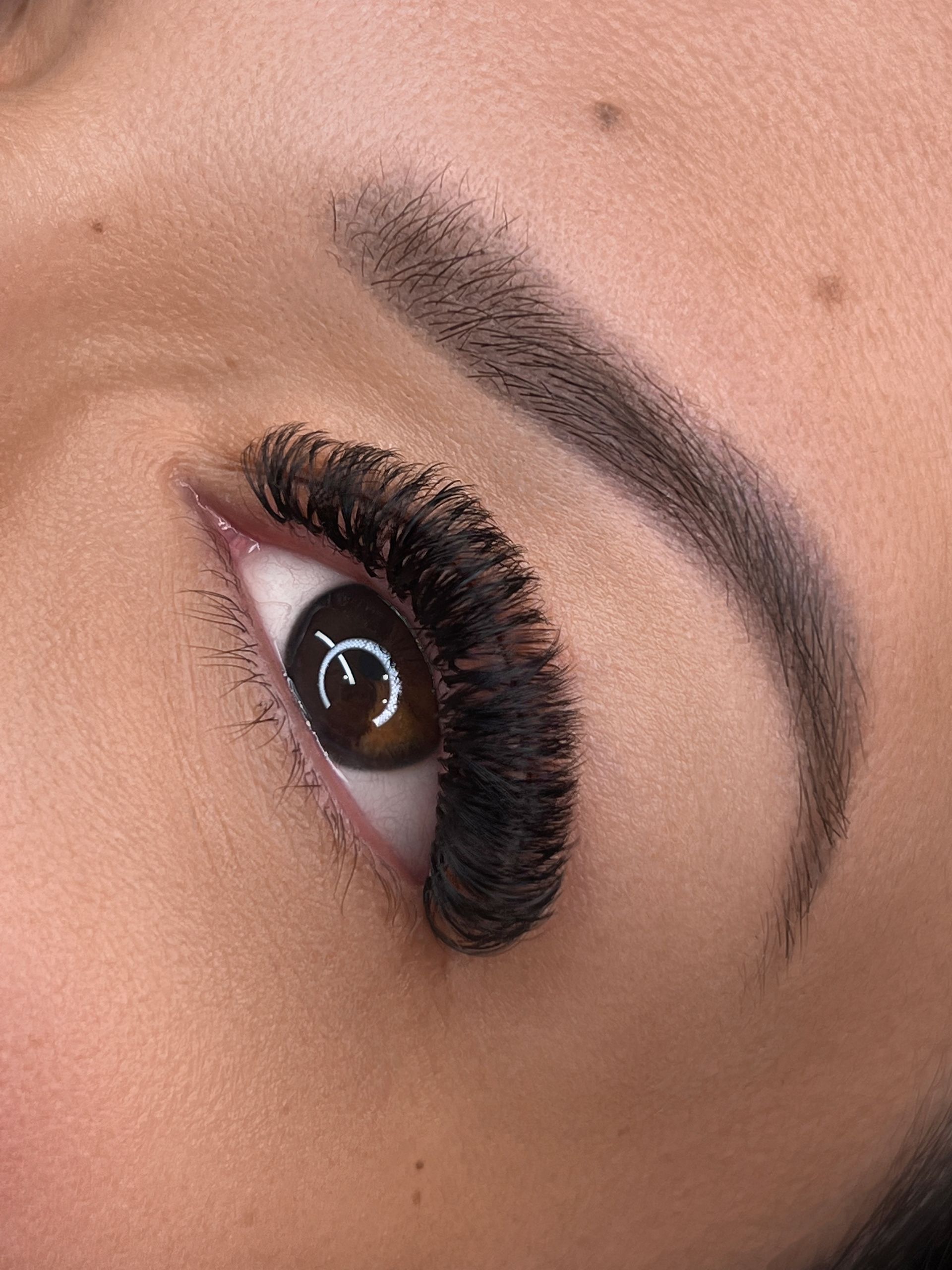 Eine Nahaufnahme des Auges einer Frau mit langen Wimpern.
