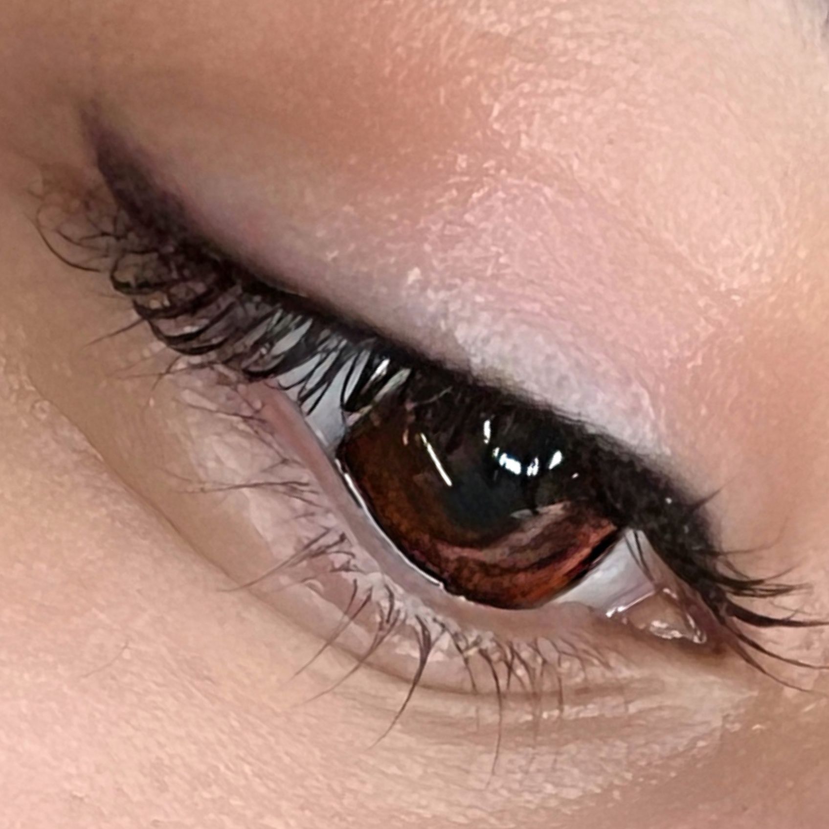 Eine Nahaufnahme des Auges einer Frau mit langen Wimpern.