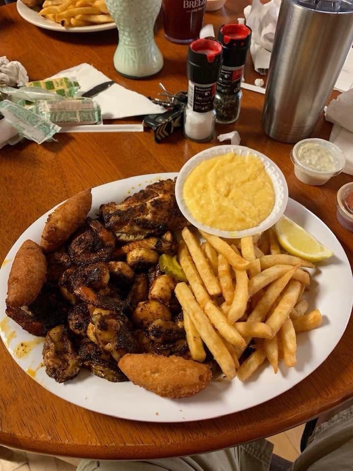 A plate of food with french fries and cornbread on a table.
