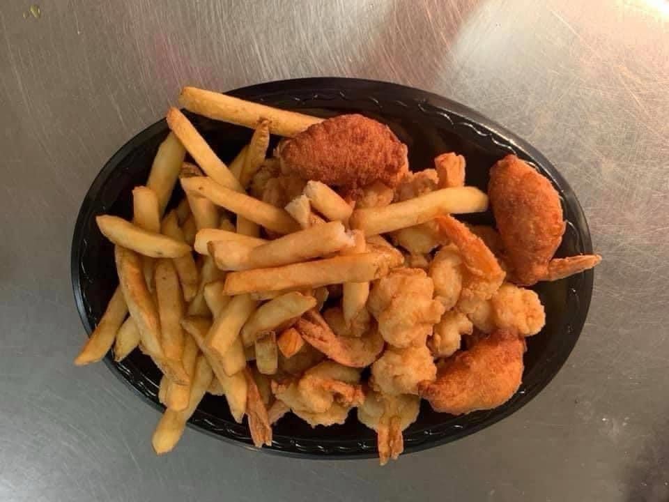 A plate of shrimp and french fries on a table.