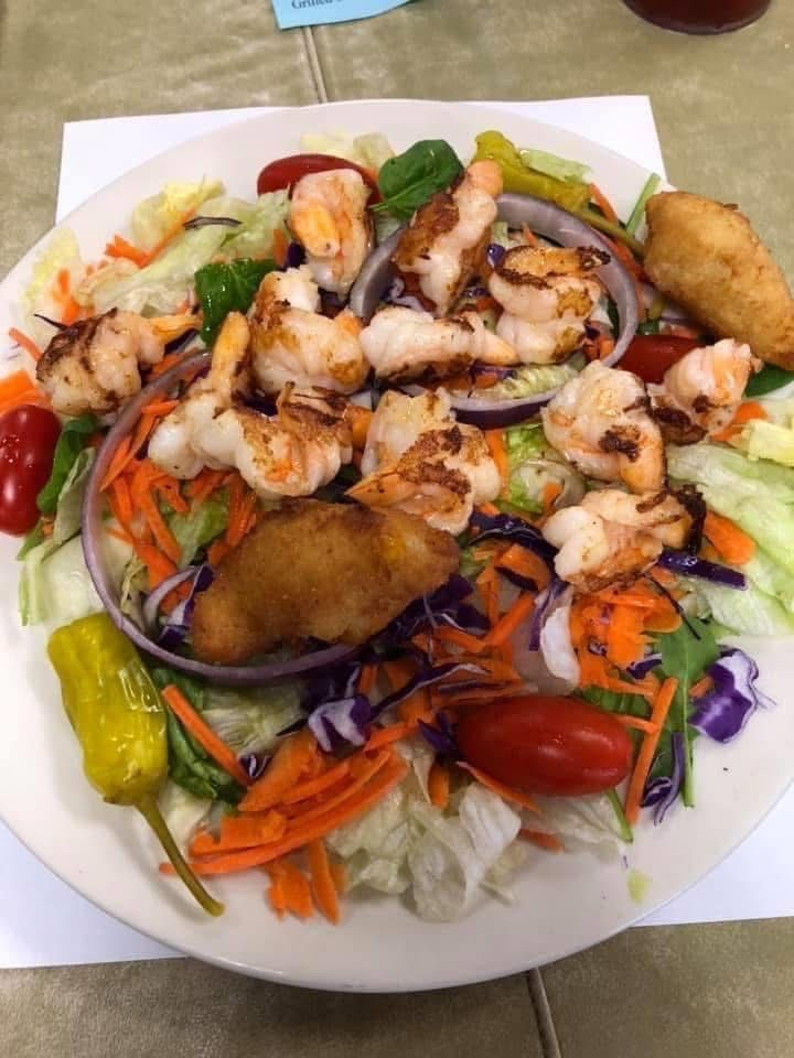 A plate of food with shrimp and vegetables on a table