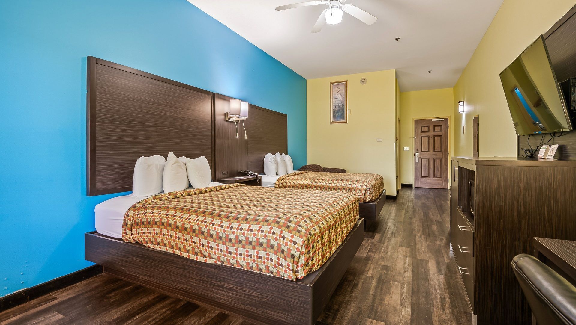 A hotel room with two beds and a ceiling fan.