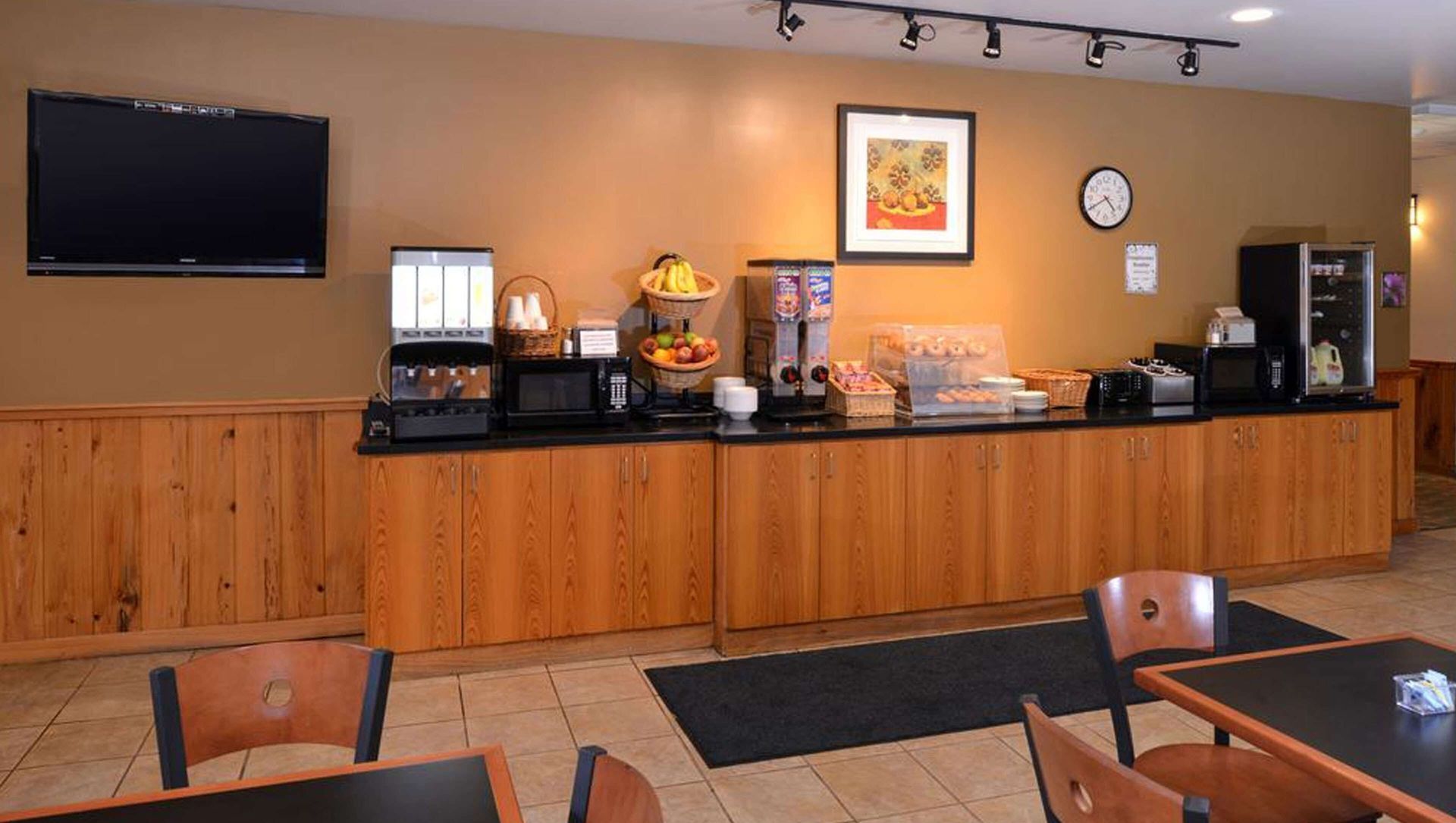 A restaurant with tables and chairs and a tv on the wall