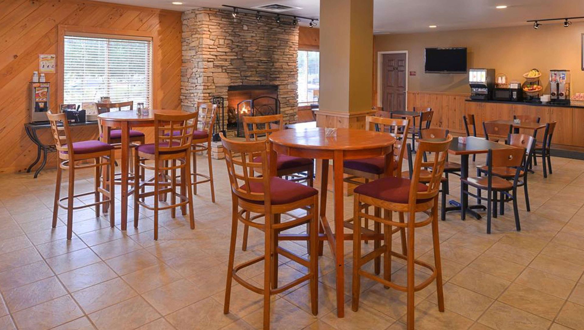 A restaurant with tables and chairs and a fireplace