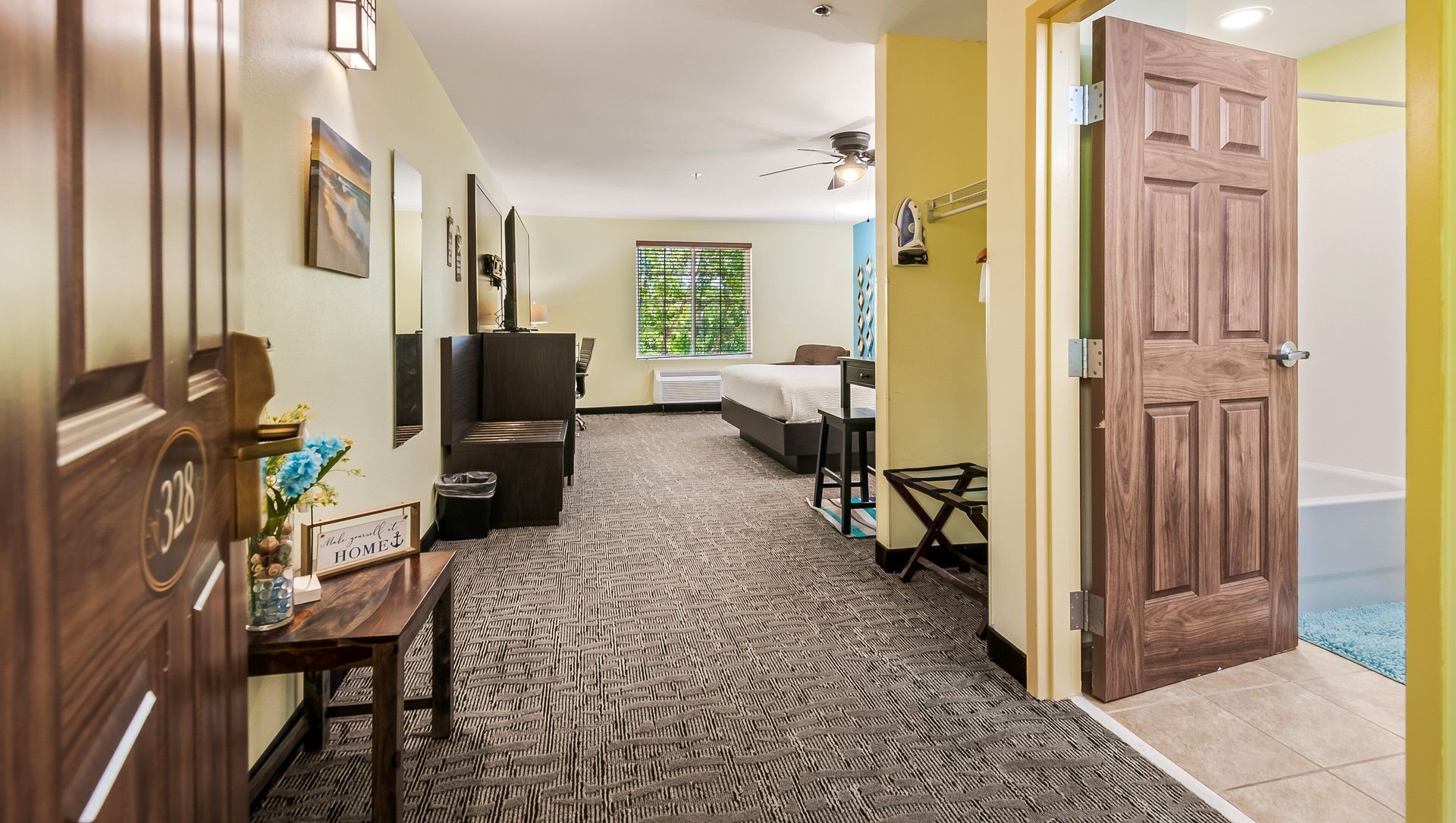 A hotel room with two beds , a table and a door.