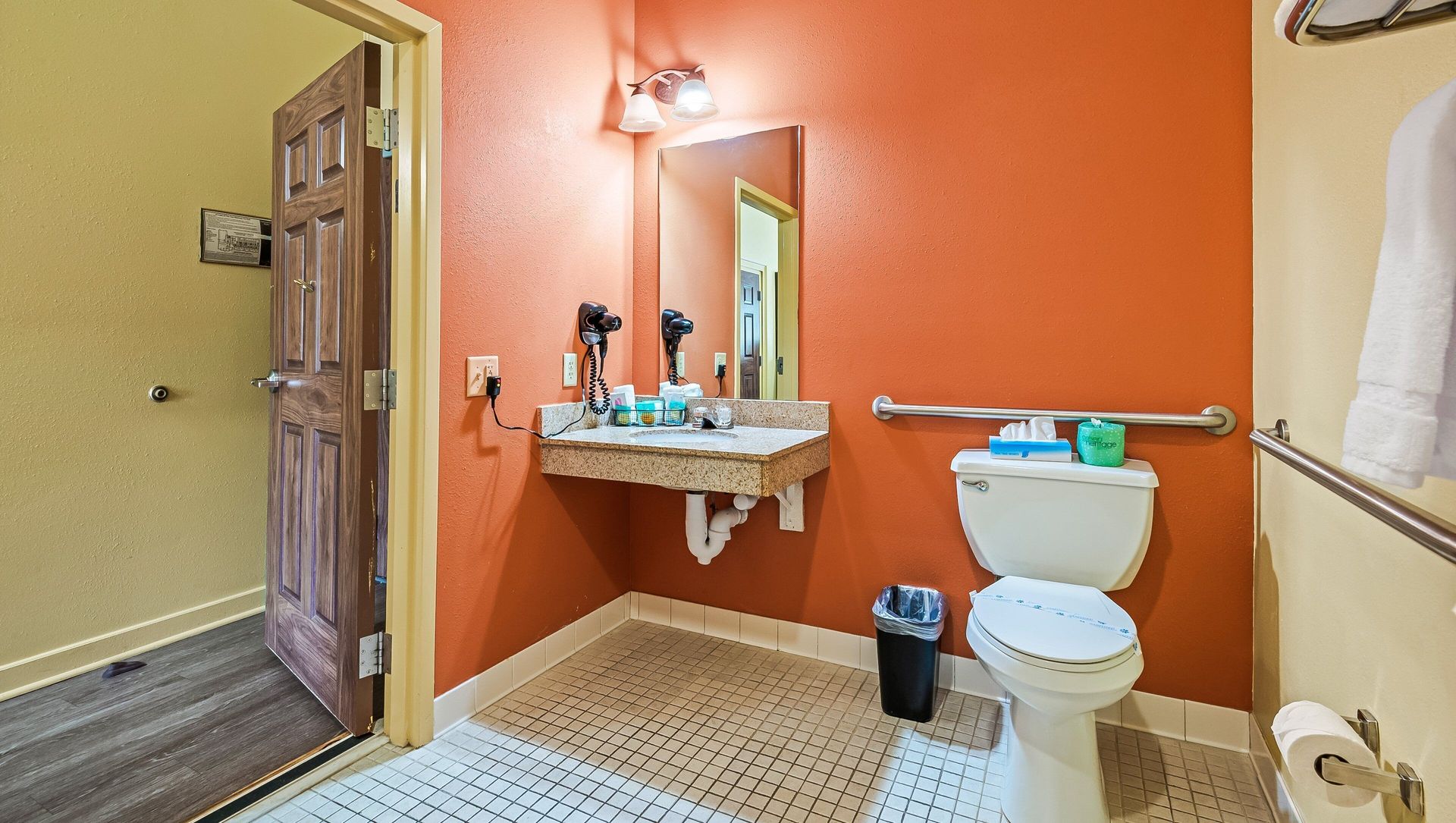 A bathroom with a toilet , sink and mirror.