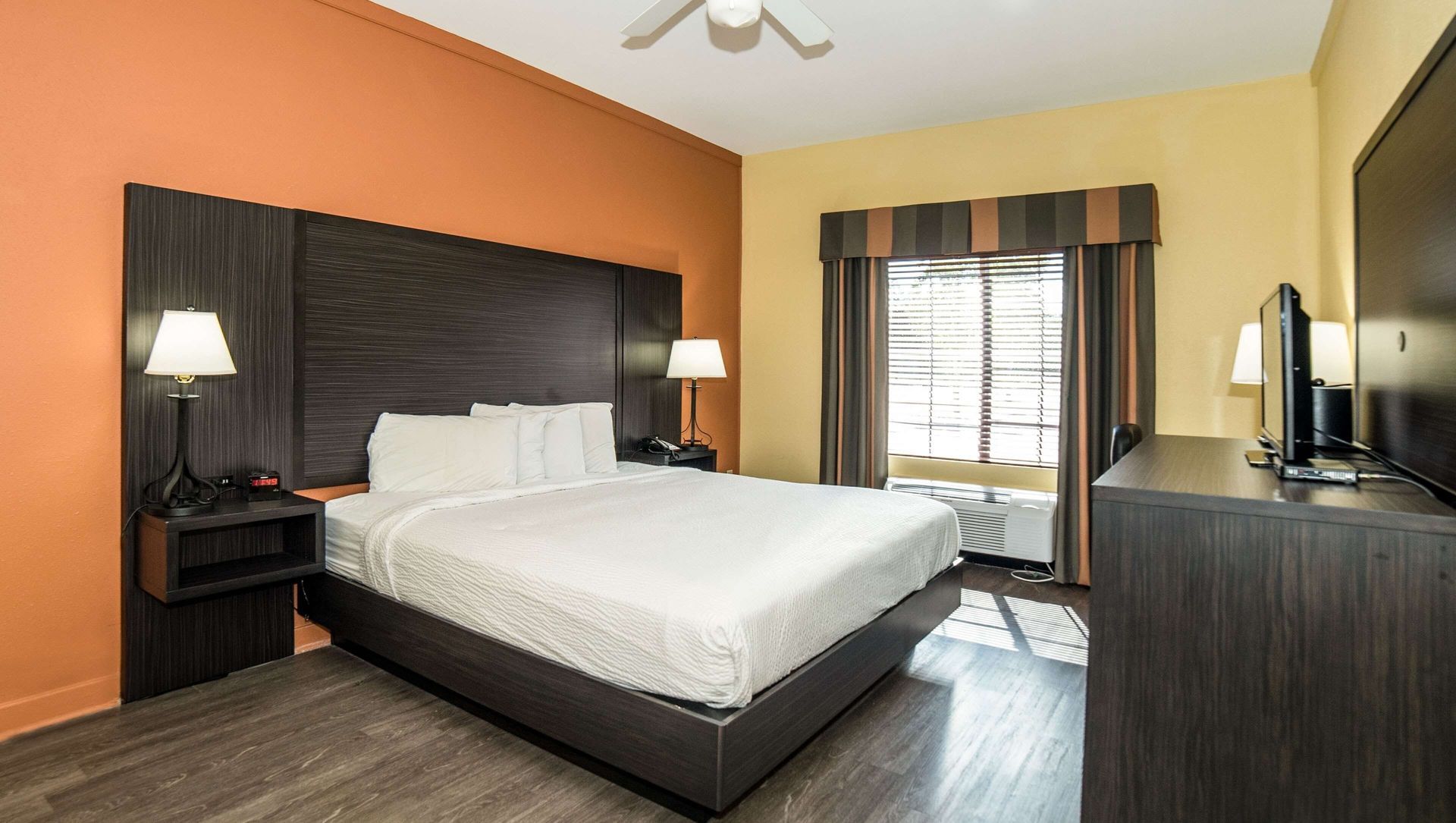 A hotel room with a king size bed and a flat screen tv.