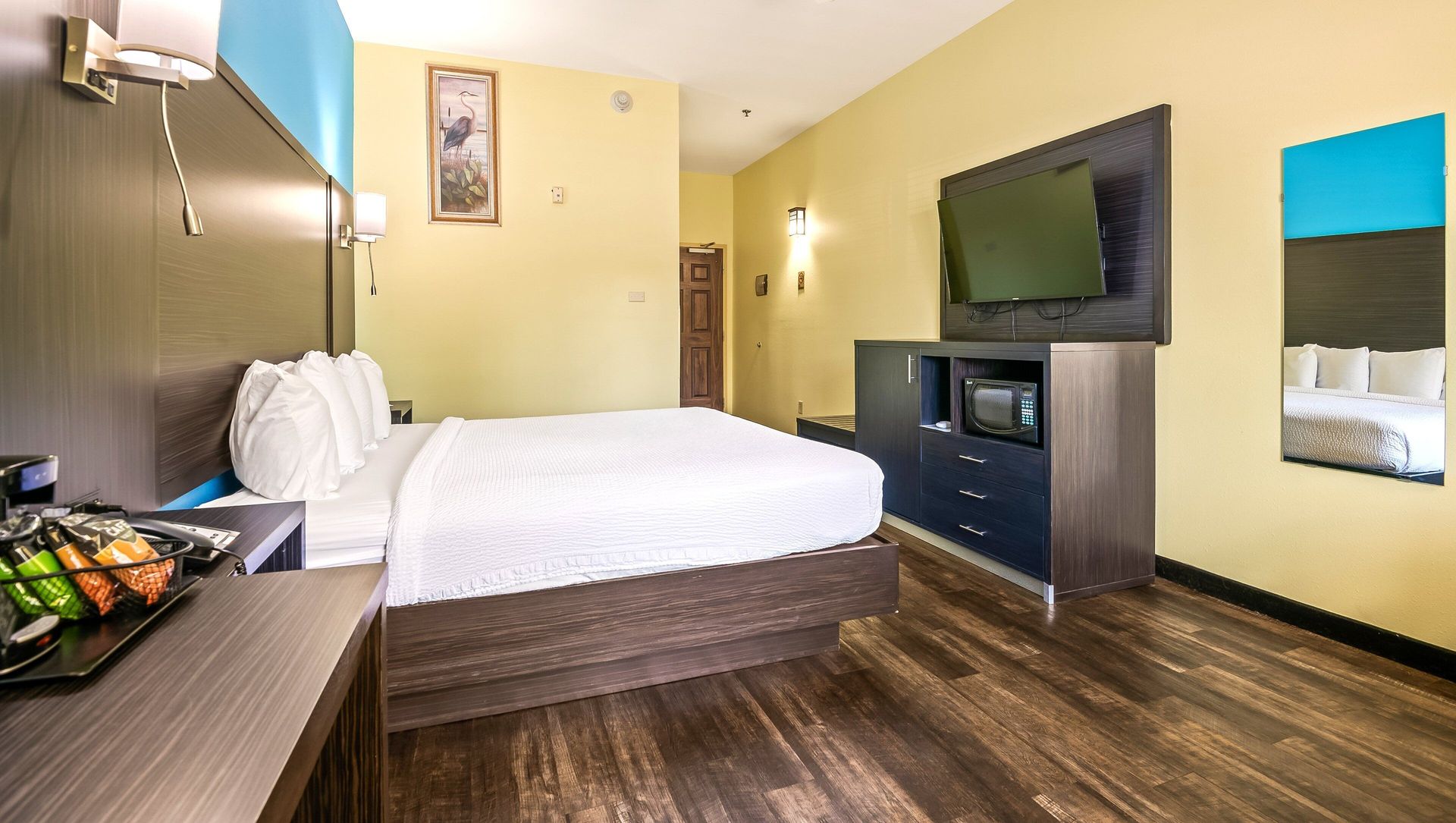 A hotel room with a king size bed and a flat screen tv.