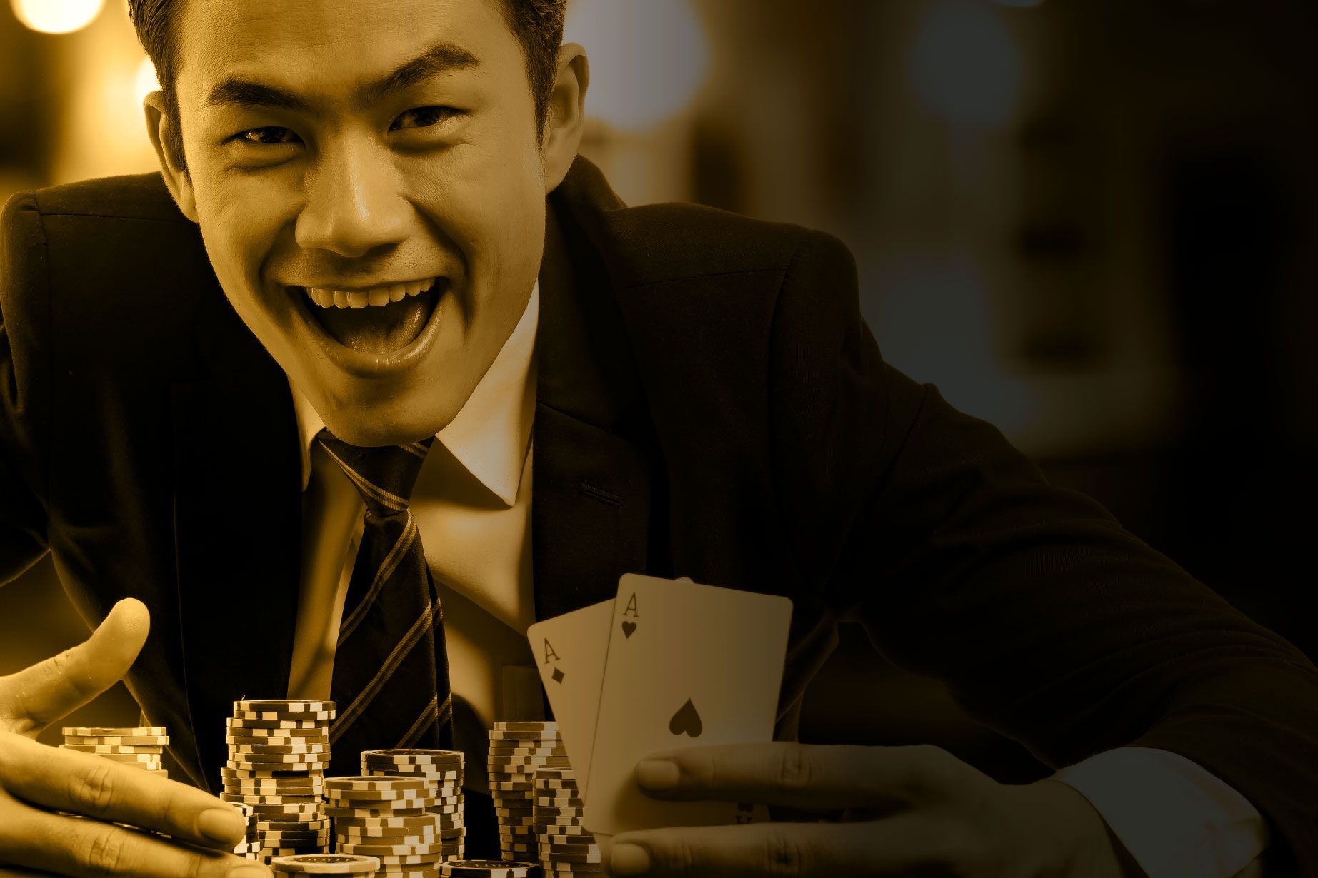 A man in a suit and tie is holding a pile of poker chips and playing cards