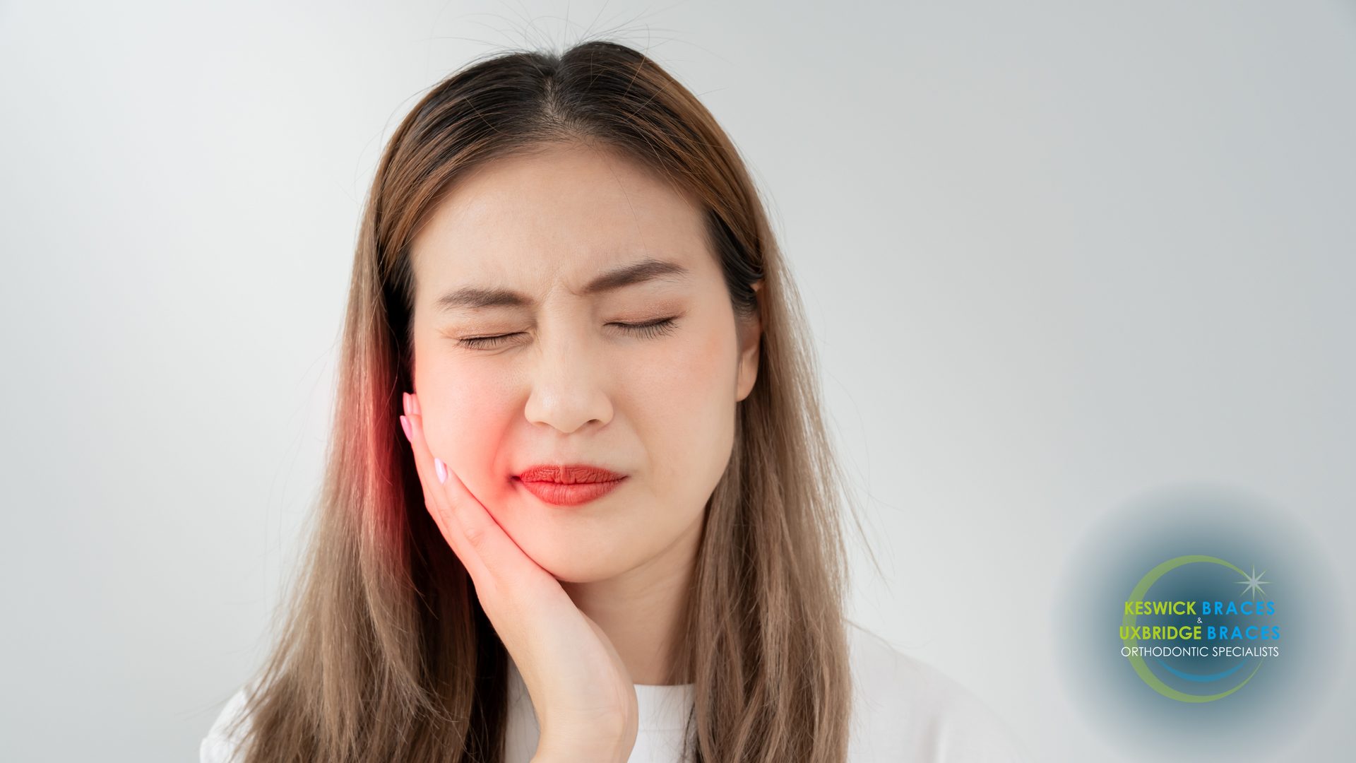 A woman is holding her face in pain because of a toothache.