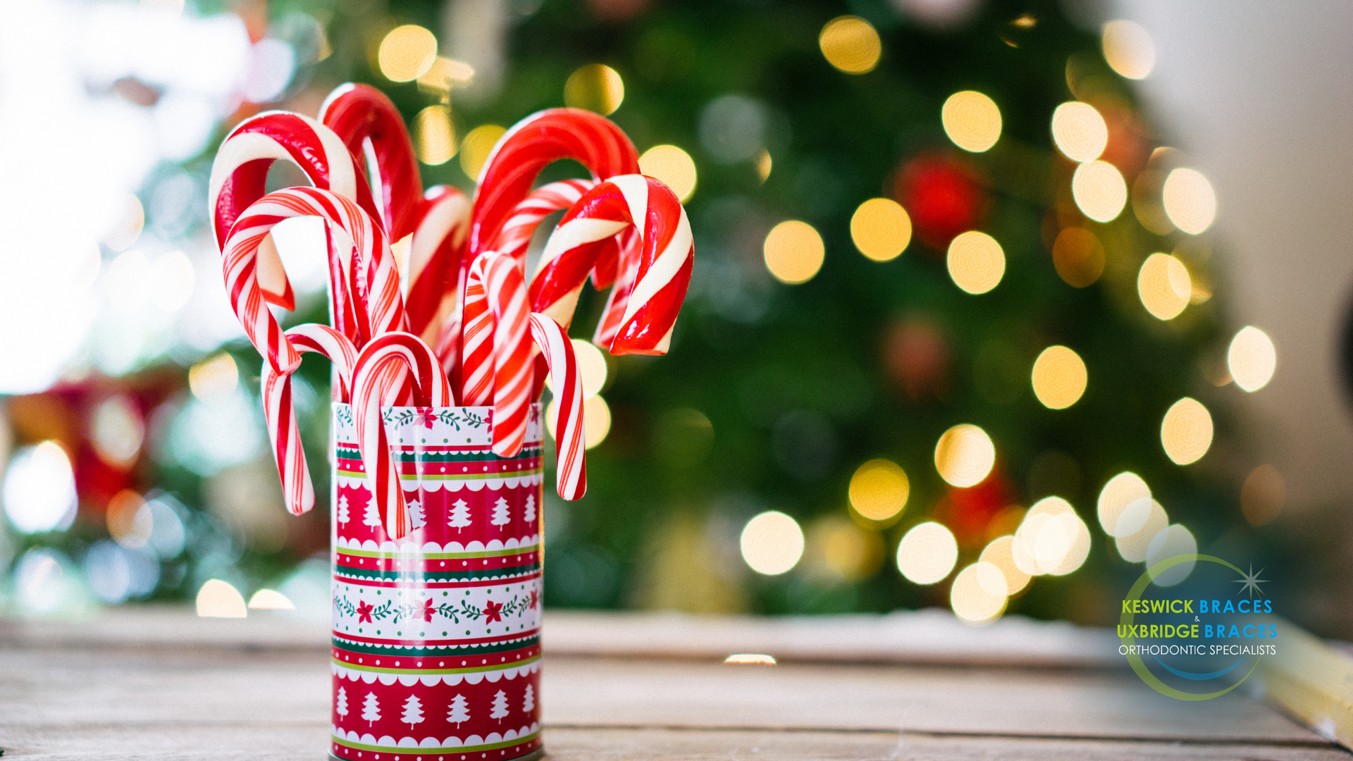 A vase filled with candy canes in front of a christmas tree.