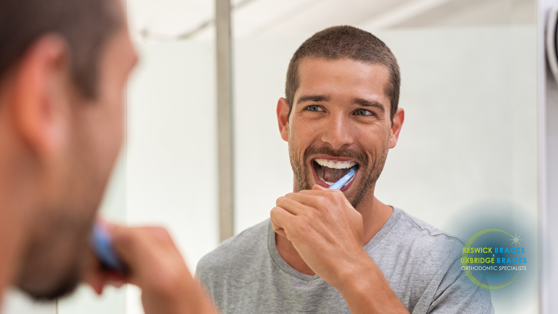 A man is brushing his teeth in front of a mirror.