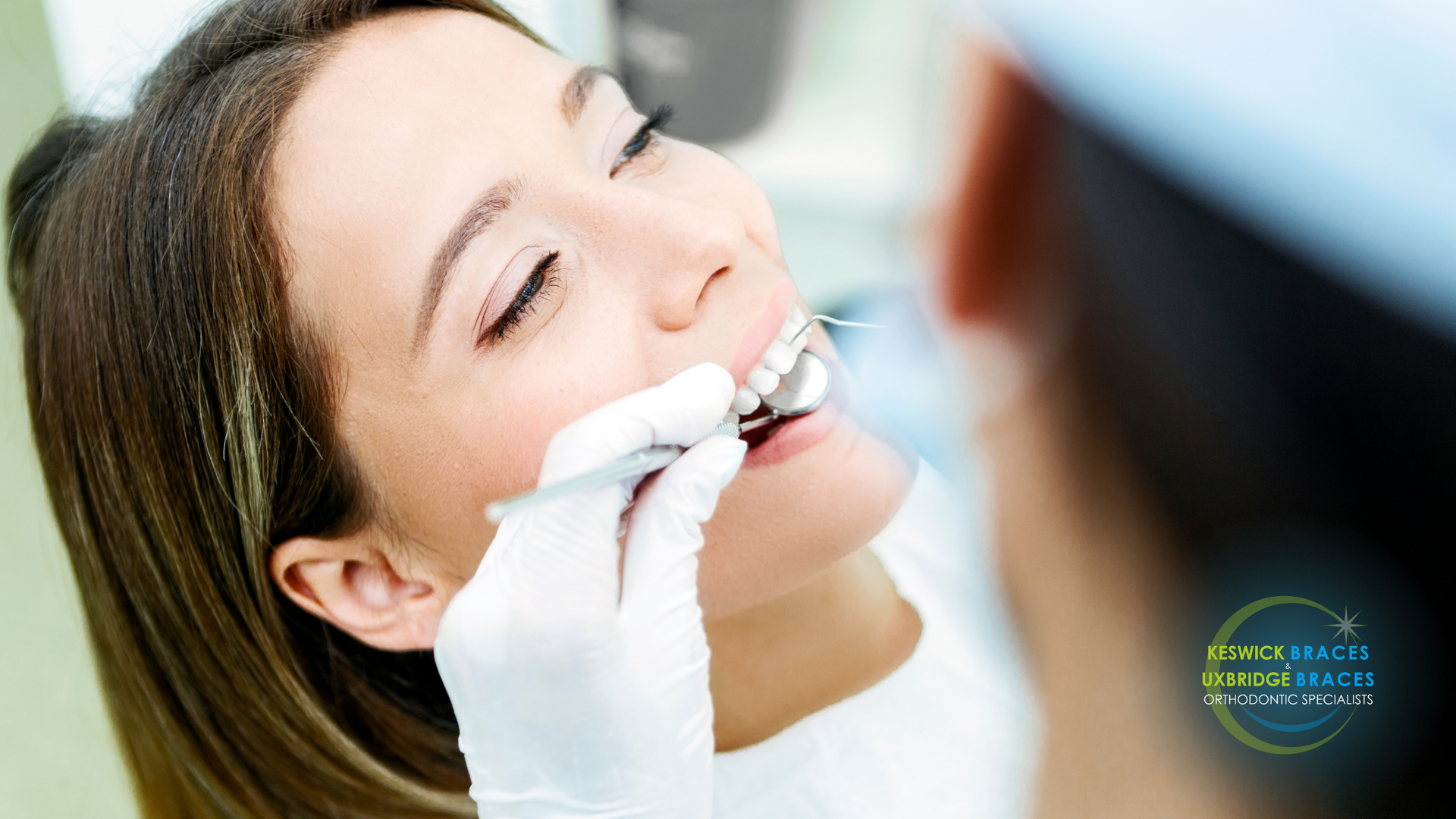 A woman is getting her teeth examined by a dentist.