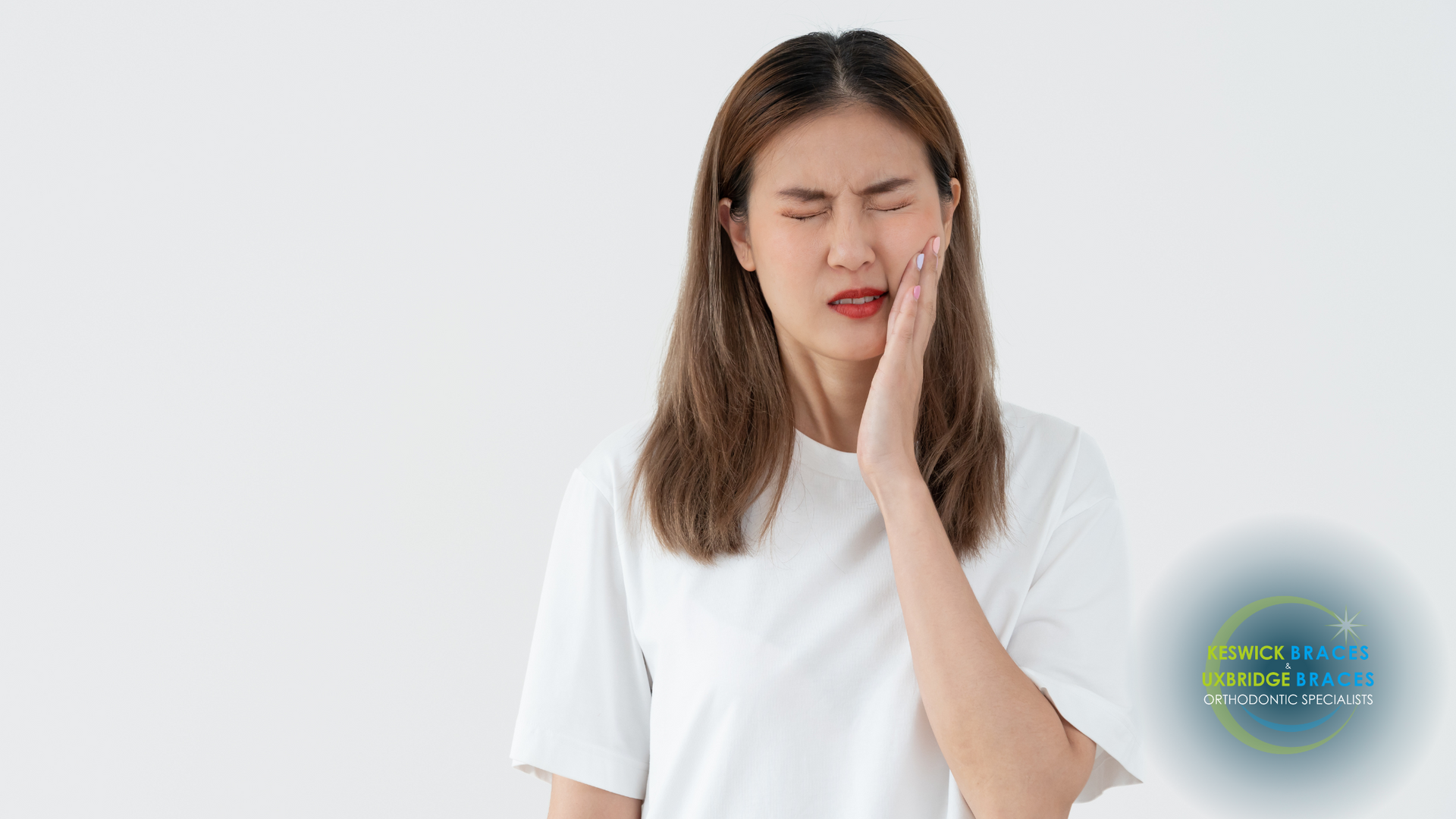 A woman is holding her face in pain because of a toothache.