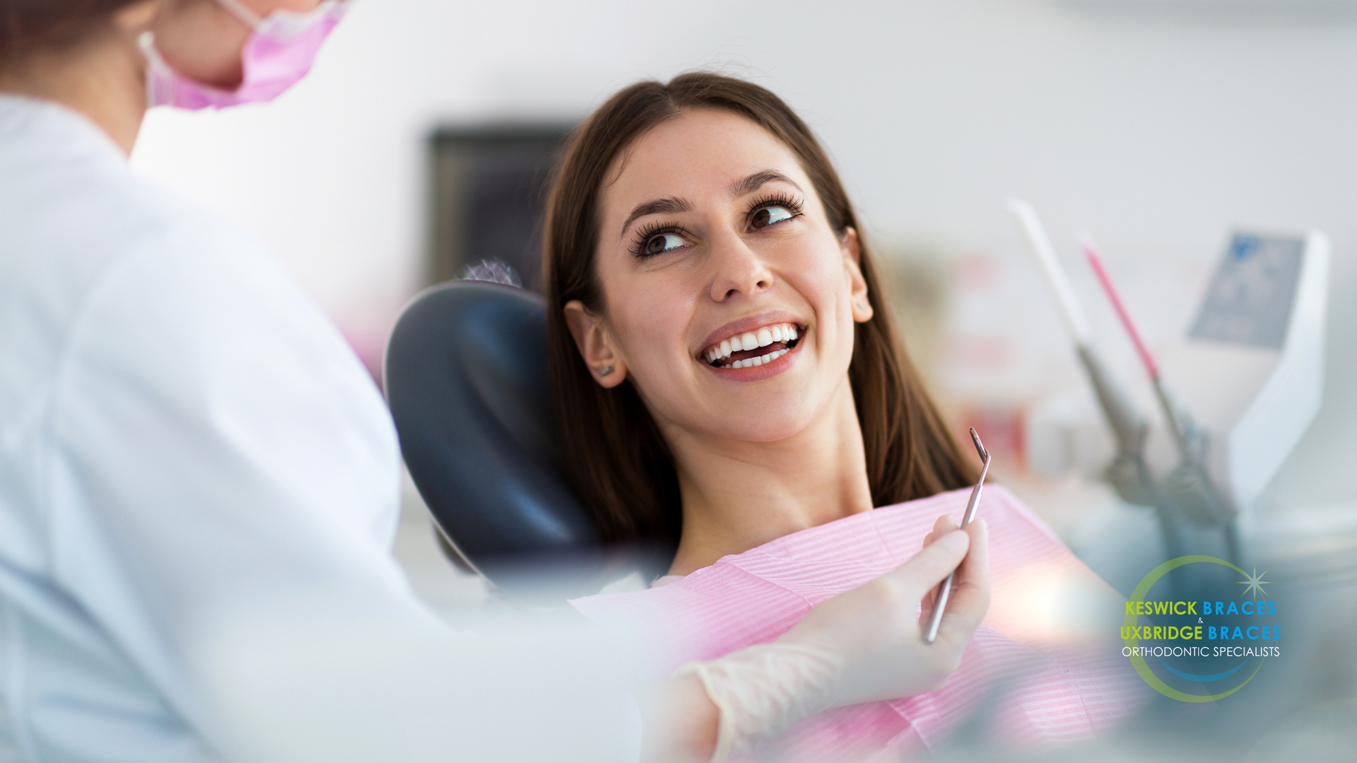 A woman is smiling while sitting in a dental chair.