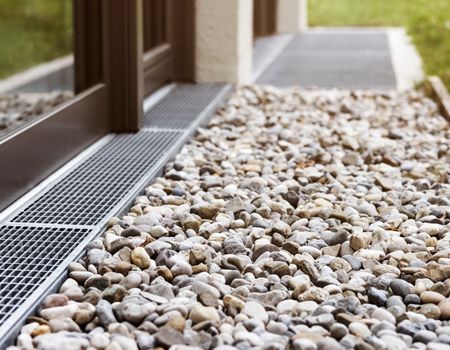 A gravel walkway with a metal grate underneath it