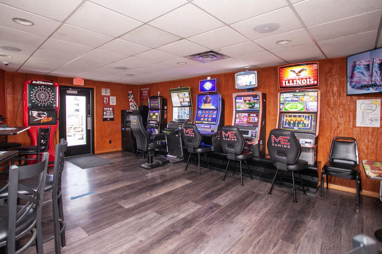 Inside a gaming area, slot machines are arranged near a dark wooden floor and panelled walls.