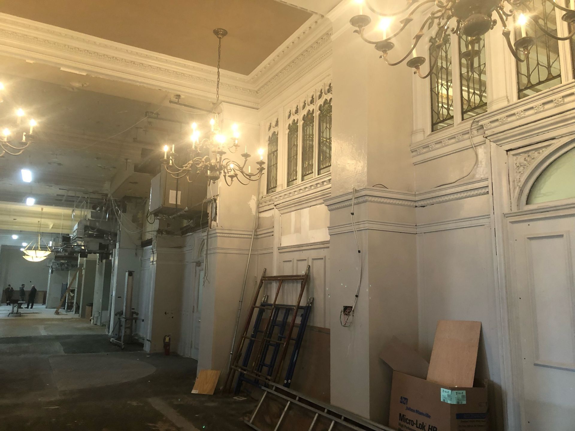 A large room with a lot of windows and a chandelier hanging from the ceiling.
