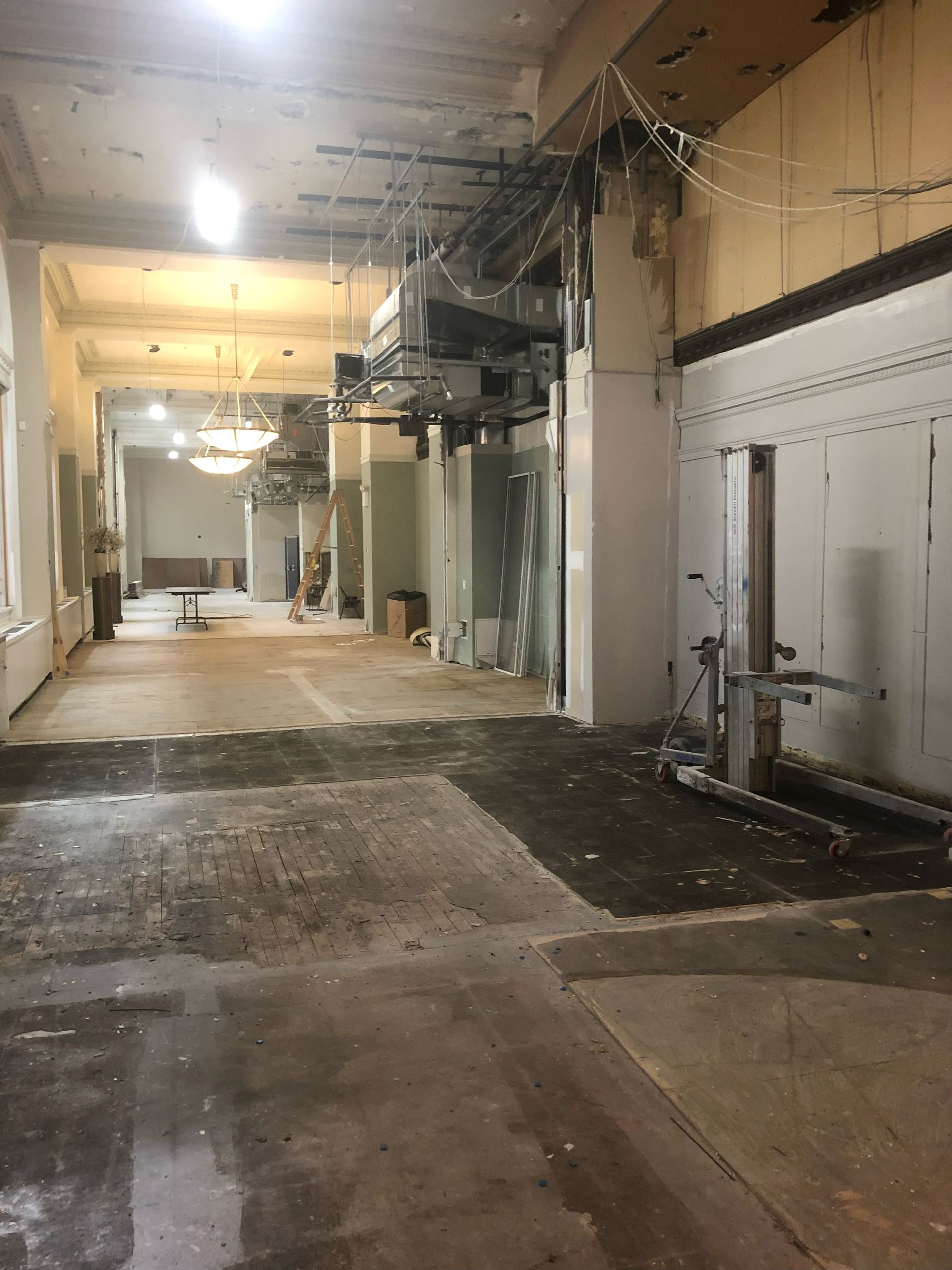 A large empty room with a lot of windows and a concrete floor.