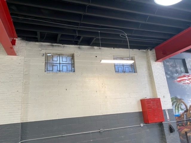 A brick wall with two windows and a light hanging from the ceiling.
