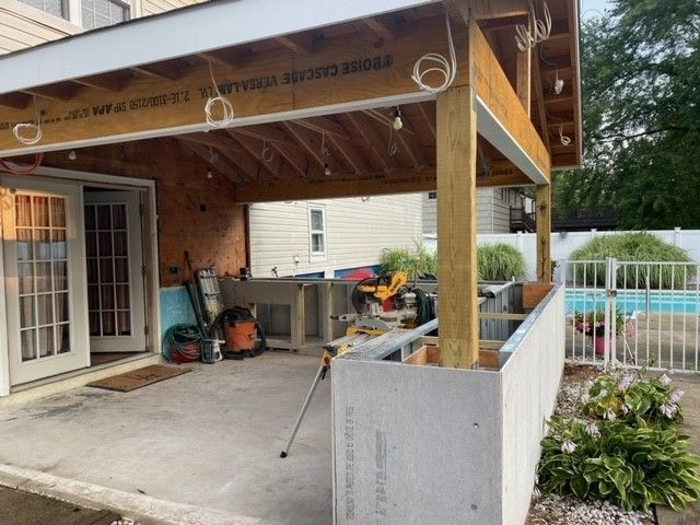 A covered patio with a pool in the background