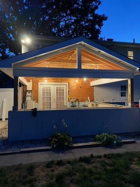 A house with a covered porch is lit up at night