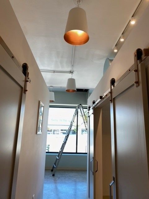 A hallway with sliding barn doors and a light hanging from the ceiling