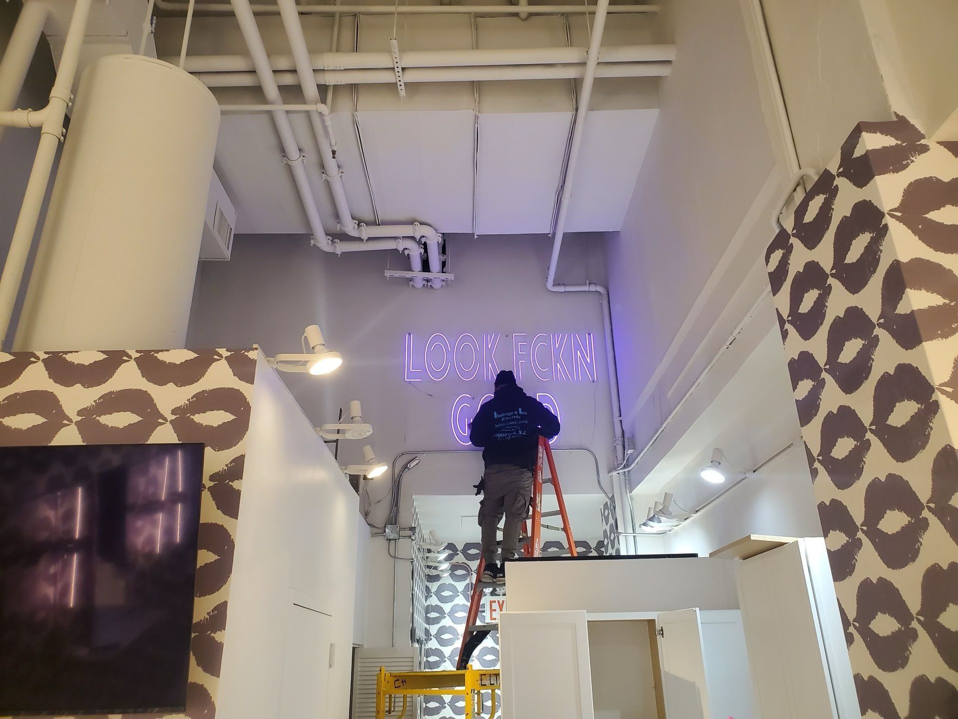 A man is standing on a ladder in front of a sign that says london