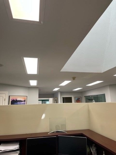 A cubicle in an office with a skylight in the ceiling