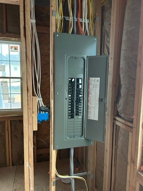 A electrical box is hanging on a wall in a room.