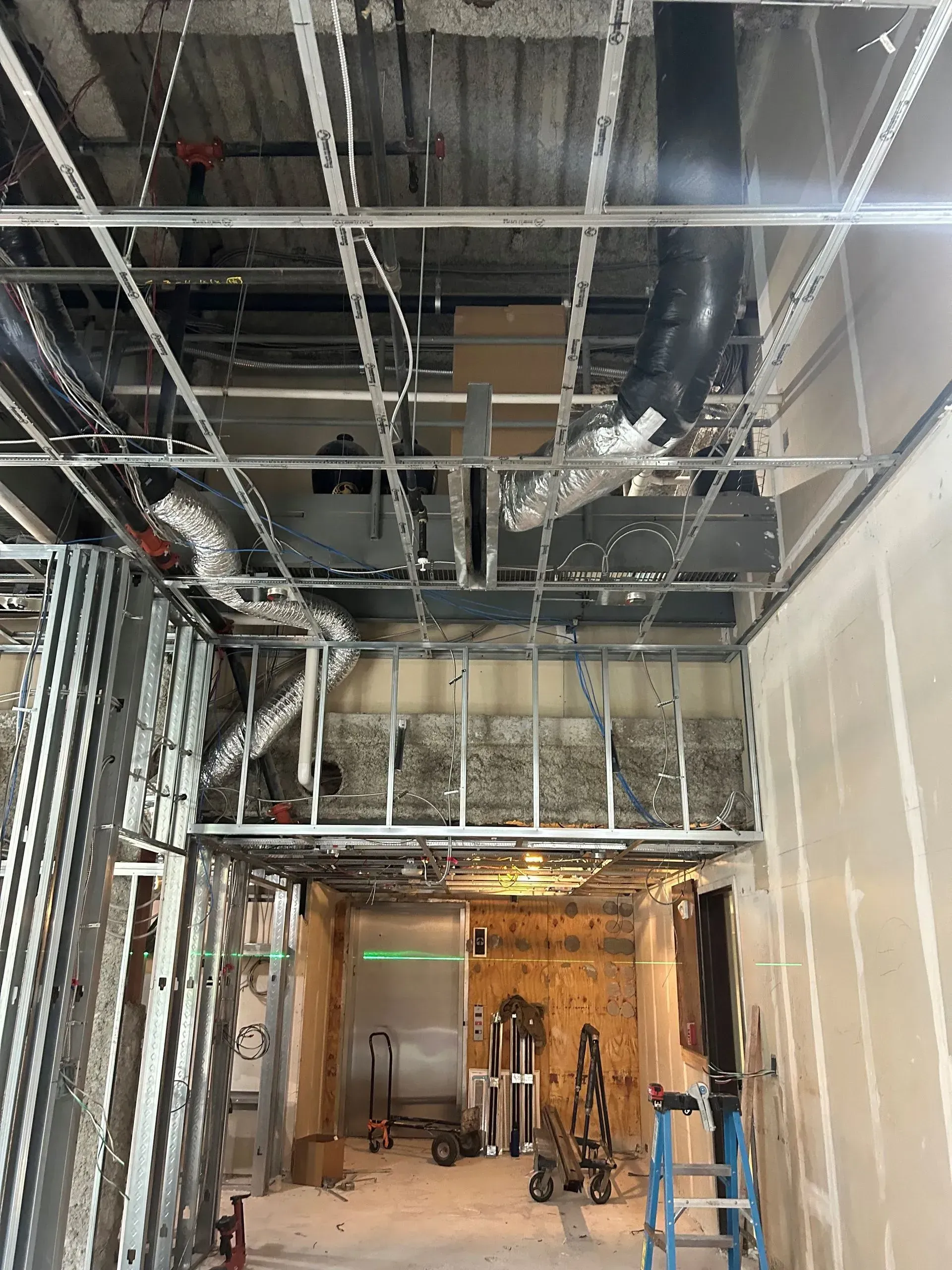 A building under construction with a ladder in the middle of the room.