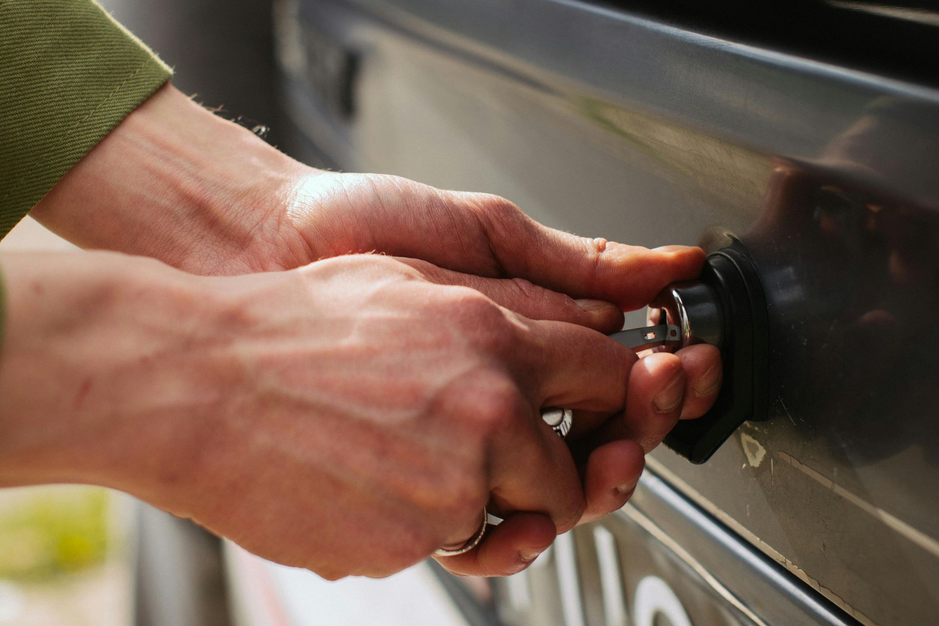 A person is turning a knob on a grill.