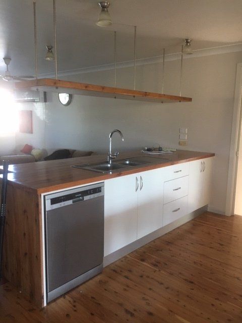 A kitchen with white cabinets and a stainless steel dishwasher