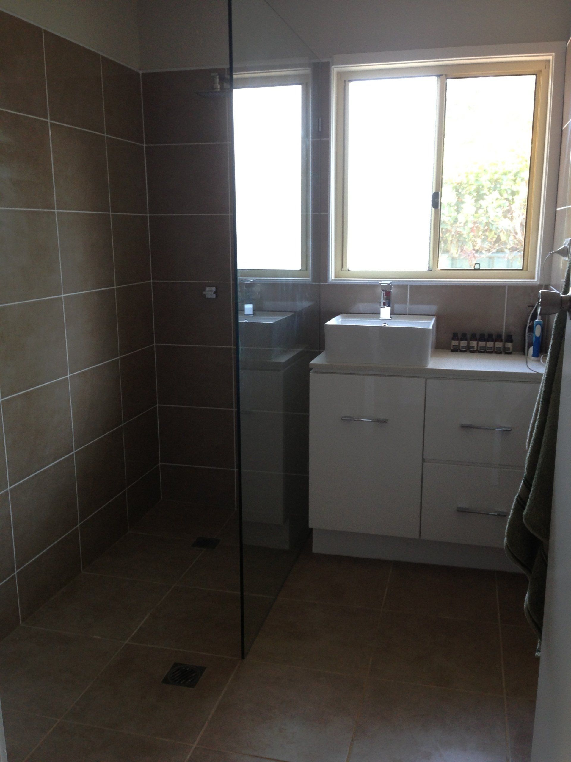 A bathroom with a sink and a walk in shower