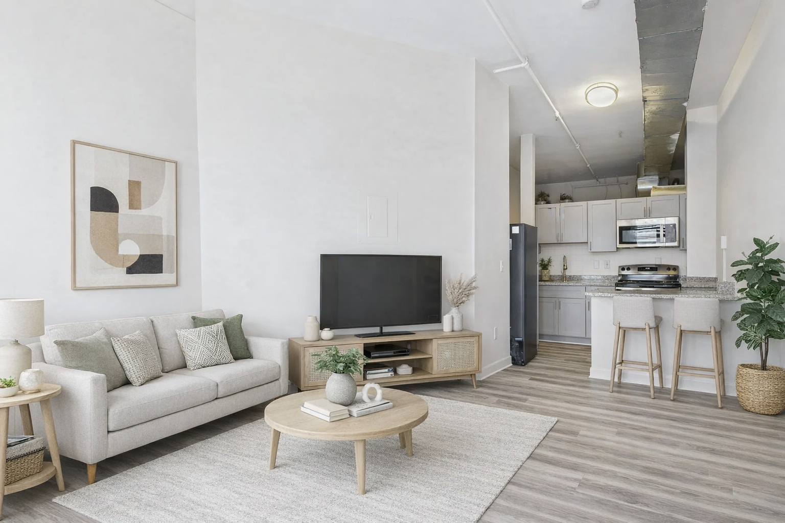 Living room with neutral tones, sofa, TV, coffee table, and open kitchen.
