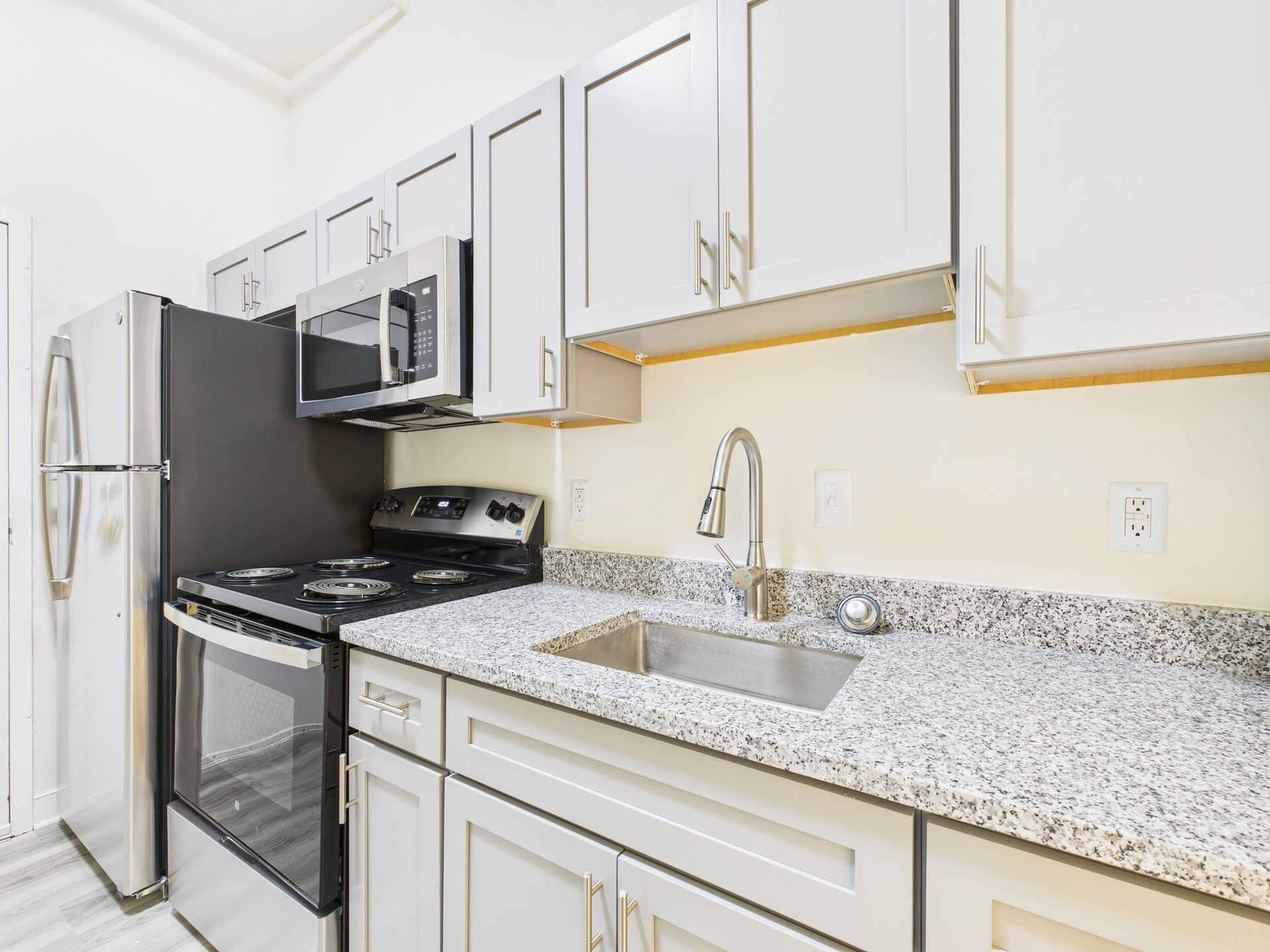 Kitchen with stainless steel appliances, light gray cabinets, and granite countertops.
