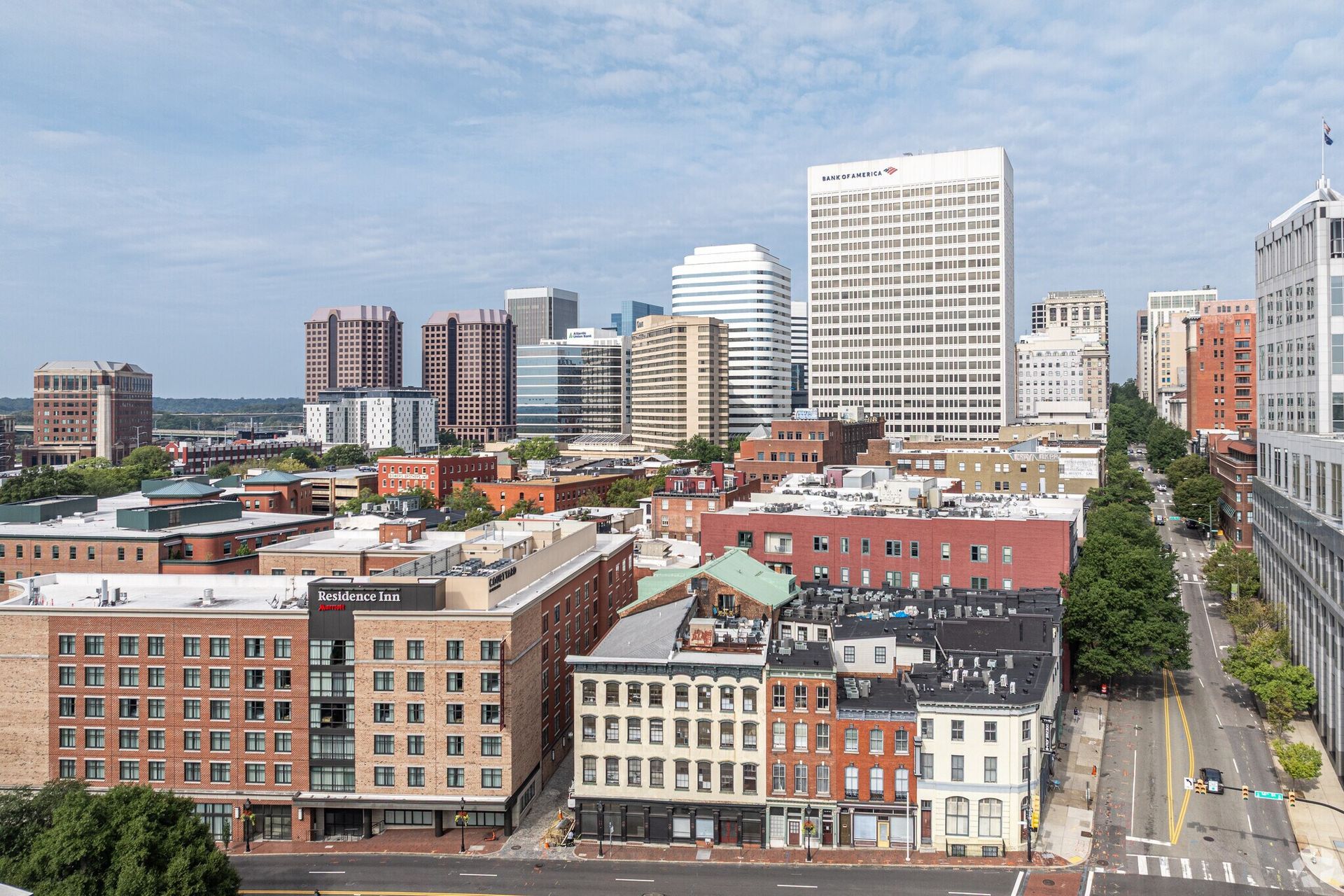 City skyline with a mix of brick and modern buildings under a blue sky.