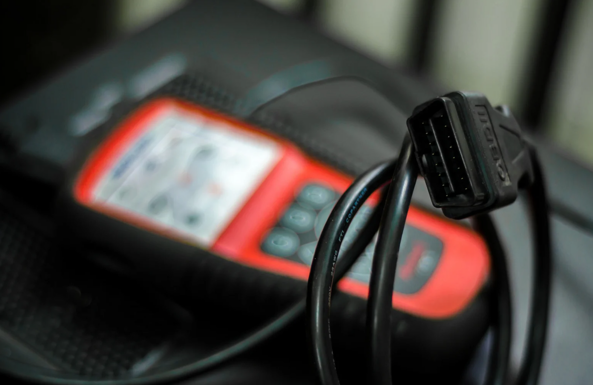 A red and black device with a cable attached to it