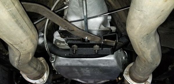 A close up of a car engine with exhaust pipes coming out of it.