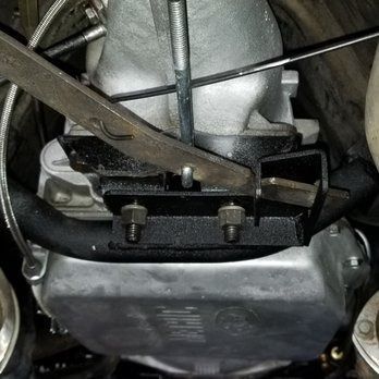 A close up of a car engine with a wrench on it.