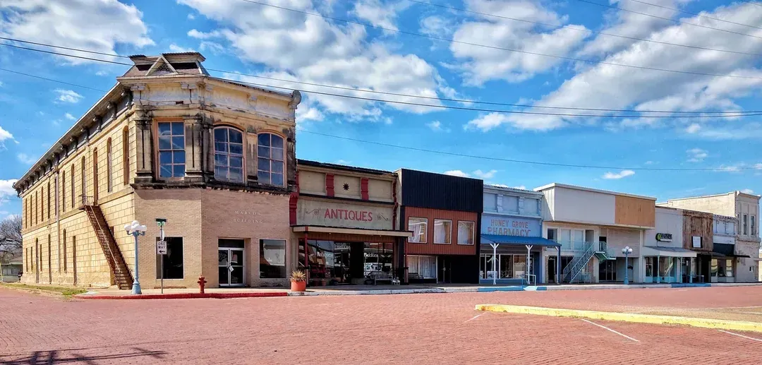 A row of buildings in a small town on a cloudy day.