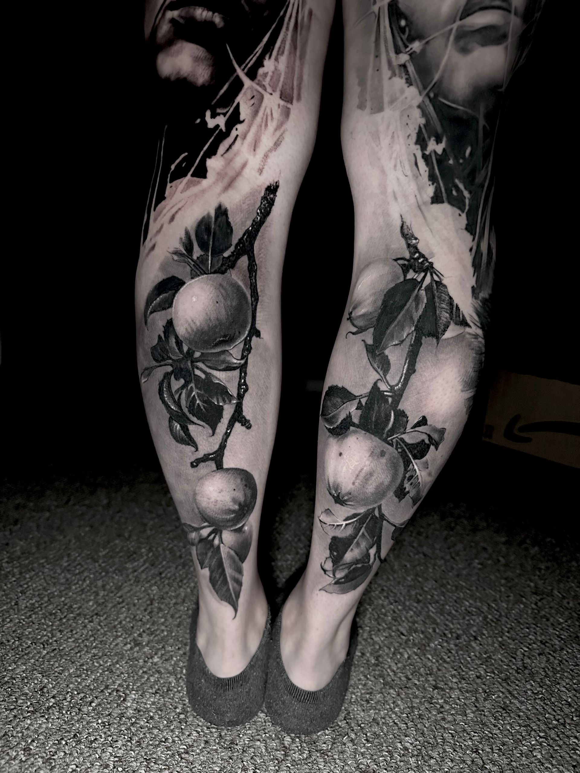 a pair of tattoos of oranges on calf