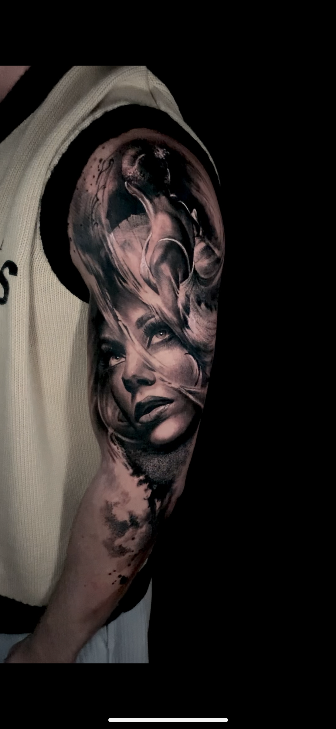 black andge tattoo of  woman on a higher arm