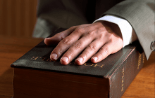 man with hand on bible