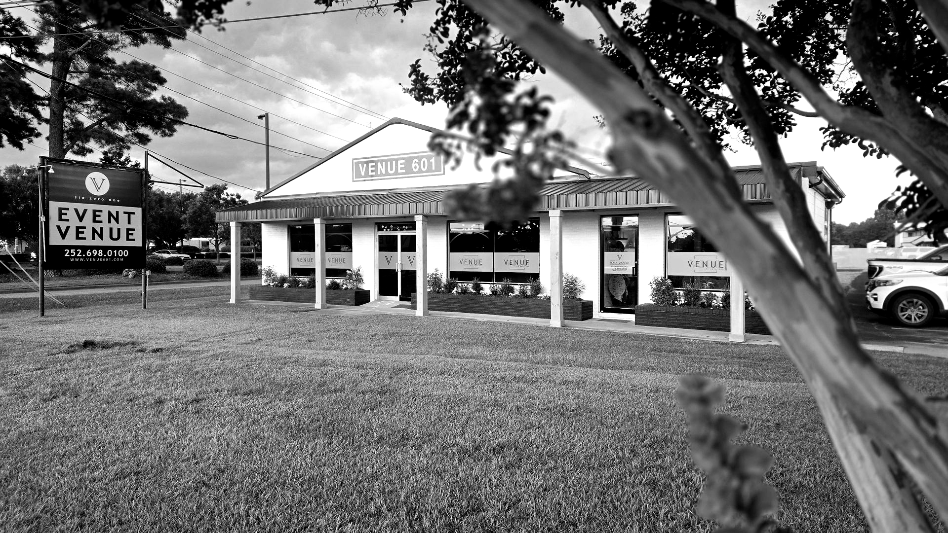 Black and white photo of a low-rise event venue with a sign that reads
