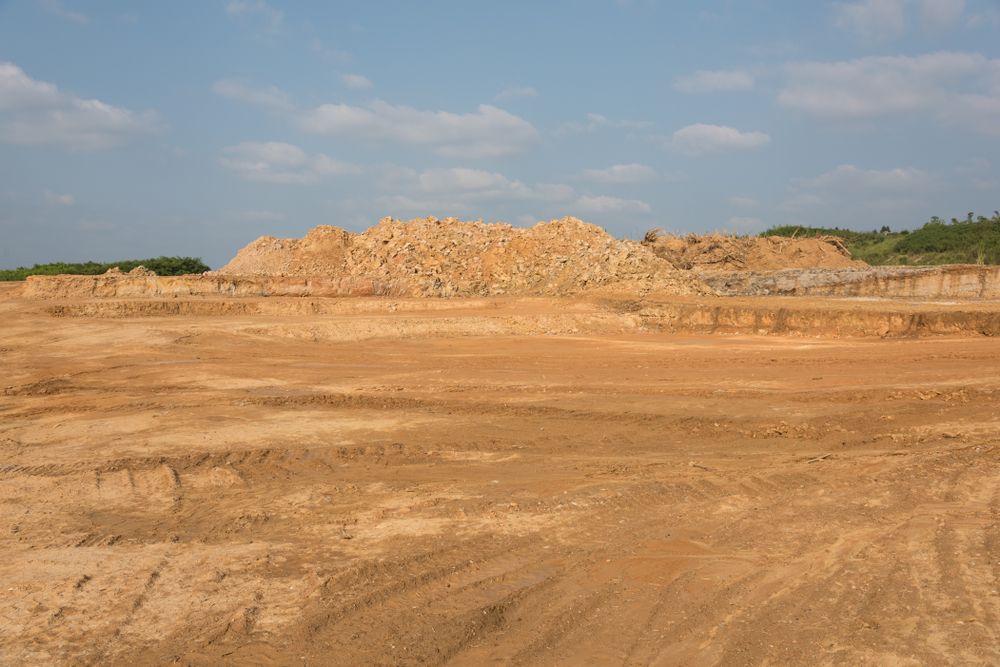 A Large Pile Of Dirt Is Sitting In The Middle Of A Dirt Field — Fewmore Contracting in Yarrawonga, NT