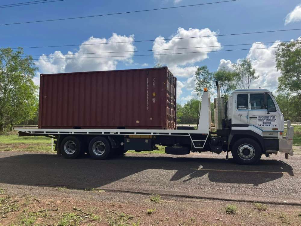 A Tow Truck With A Container On The Back Is Parked On The Side Of The Road  — Fewmore Contracting in Palmerston, NT