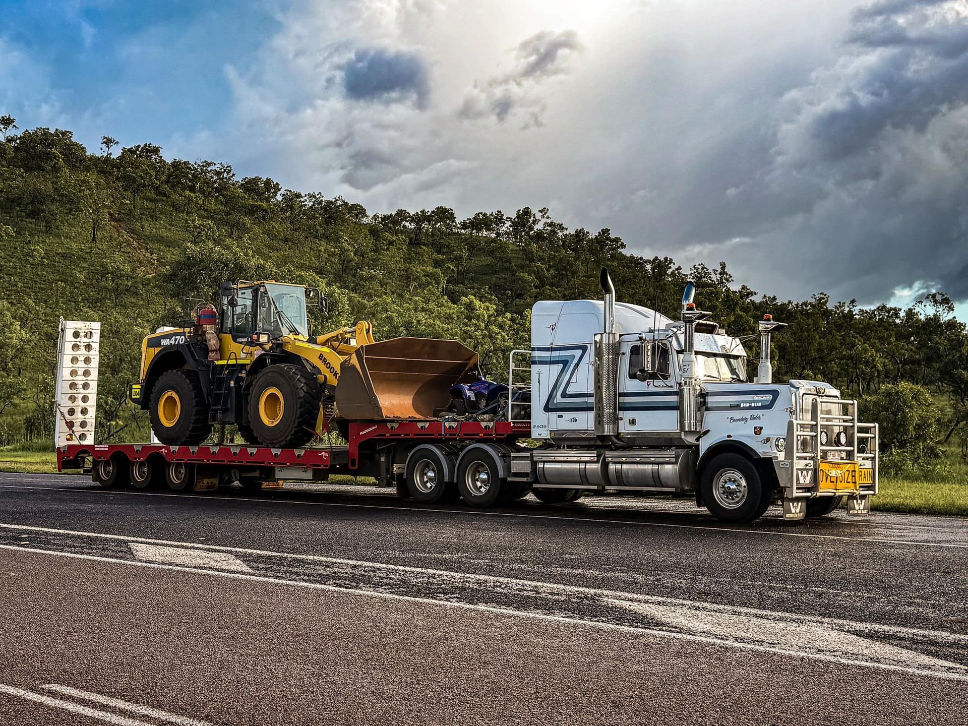 A Semi Truck is Carrying a Bulldozer on a Trailer — Fewmore Contracting in Yarrawonga, NT