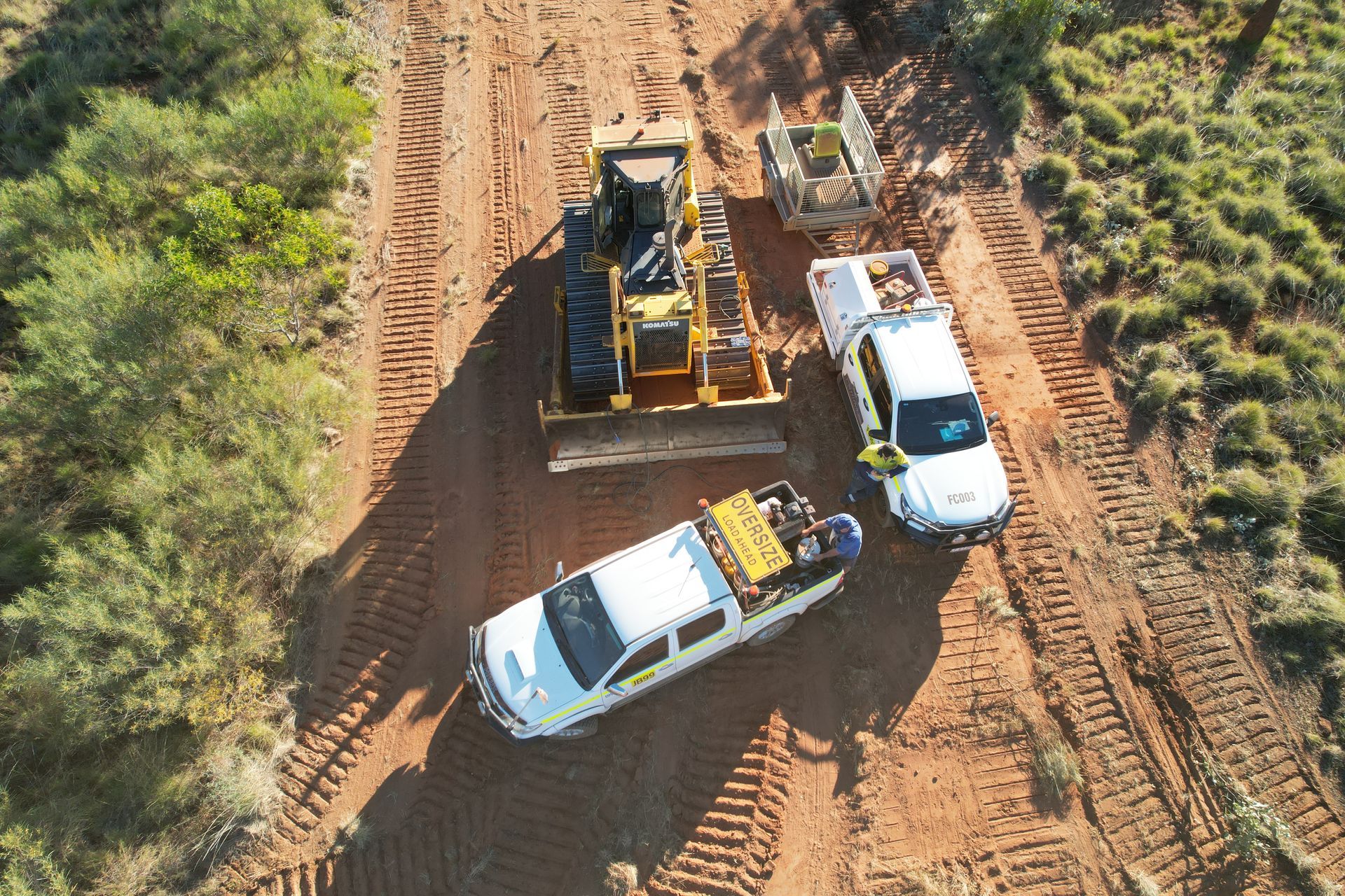 An Aerial View of a Bulldozer and a Truck on a Dirt Road — Fewmore Contracting in Yarrawonga, NT